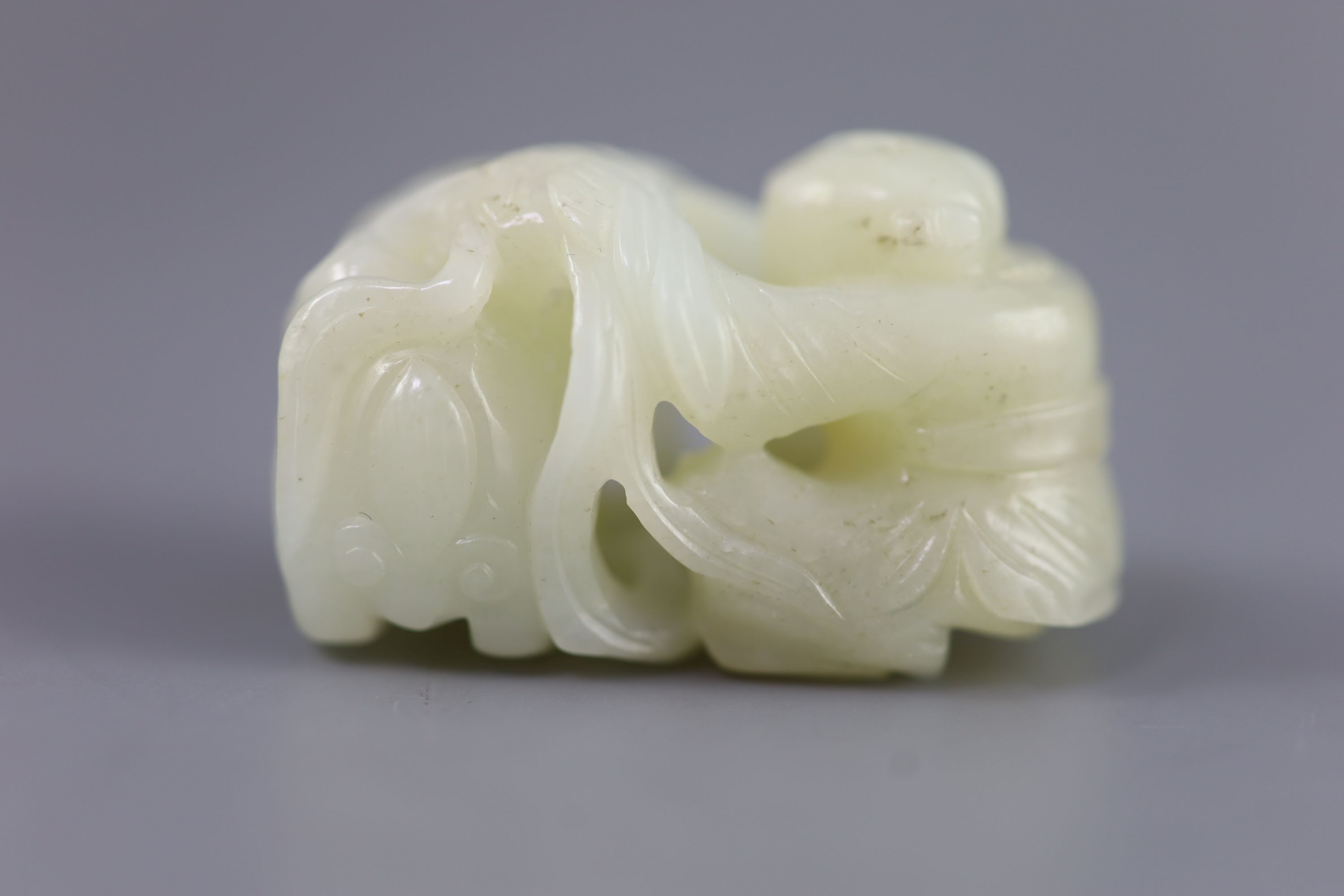 A Chinese pale celadon jade group of a boy and a lion-dog, 19th/20th century, 5.4cm